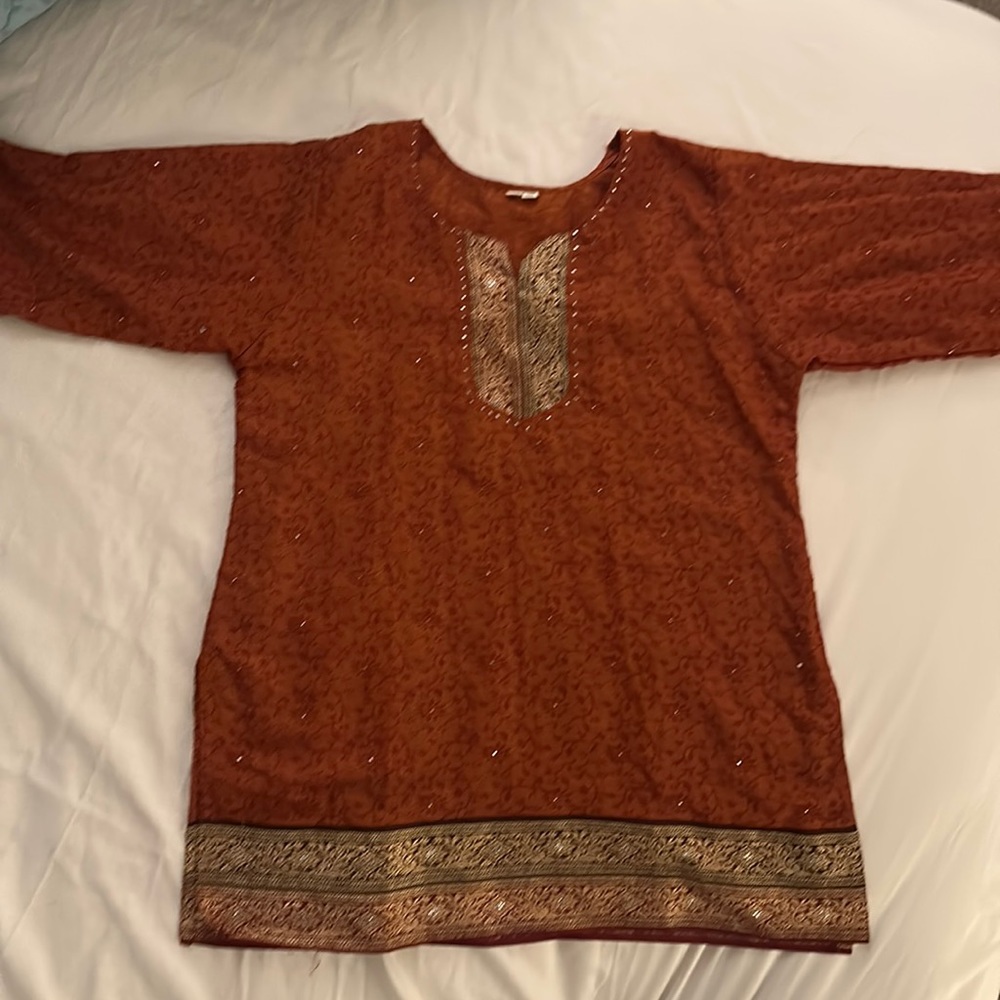 Rustic orange colored top with sequin work and gold thread design. From India